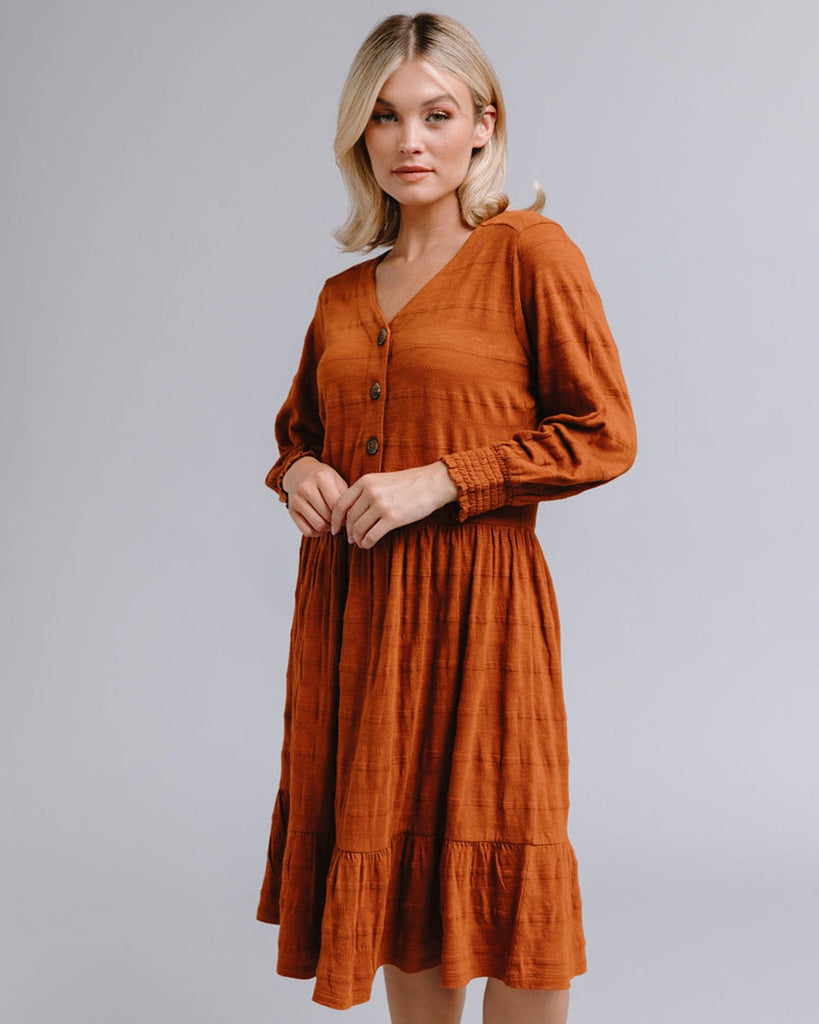 Woman in a long sleeve, button-down, orange dress