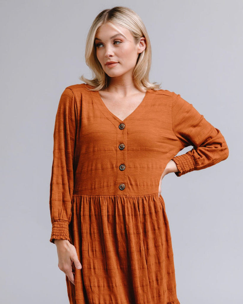 Woman in a long sleeve, button-down, orange dress