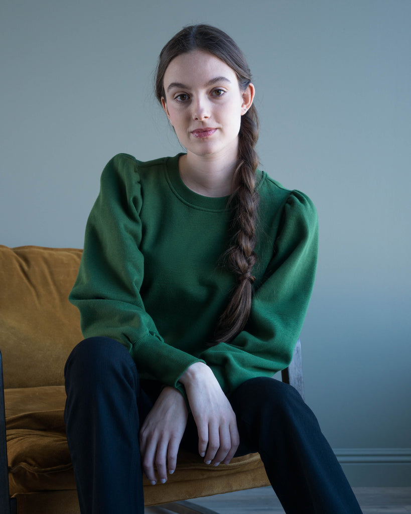 Woman in a green puffed shoulder sweatshirt