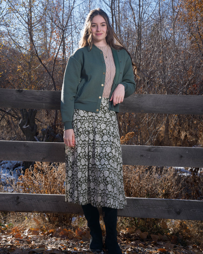 Woman in a green quilted long sleeve bomber jacket