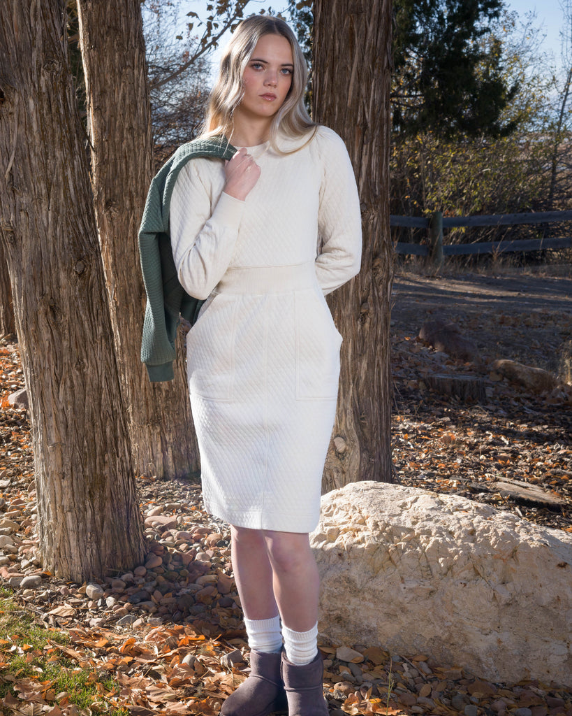 Woman in a white long sleeve, knee-length quilted dress