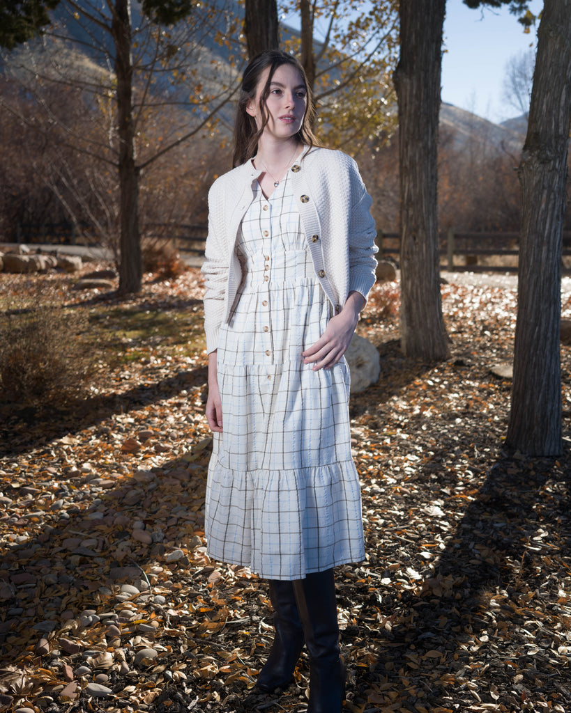 Woman in a beige plaid long sleeve midi length dress