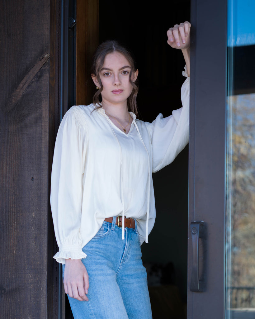 Woman in a white long sleeve v-neck blouse