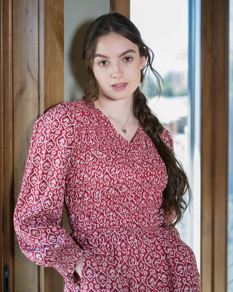 Woman in a red printed long sleeve midi-length dress