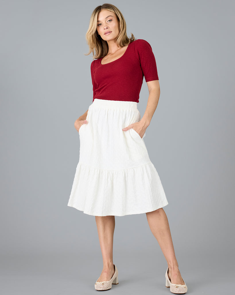 Woman in a white, knee-length textured skirt