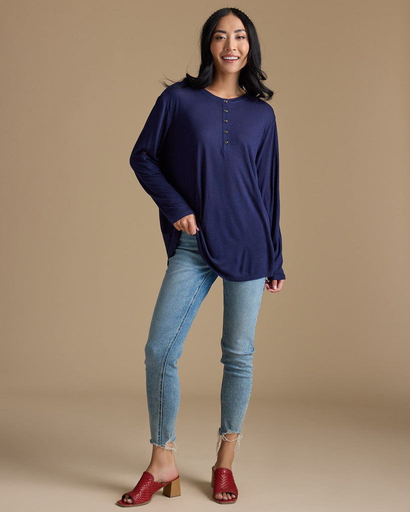 Woman in a navy, long sleeve, oversized, loose fitting blouse