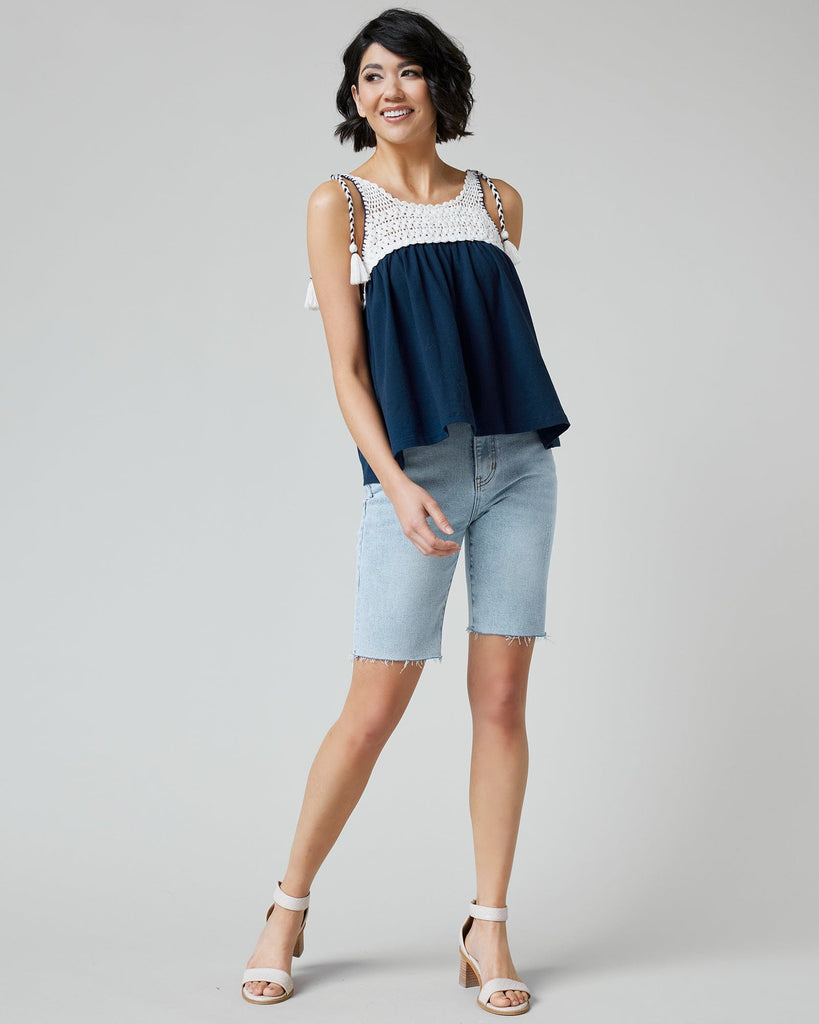 Woman in a navy tank top with crocheted fabric at top