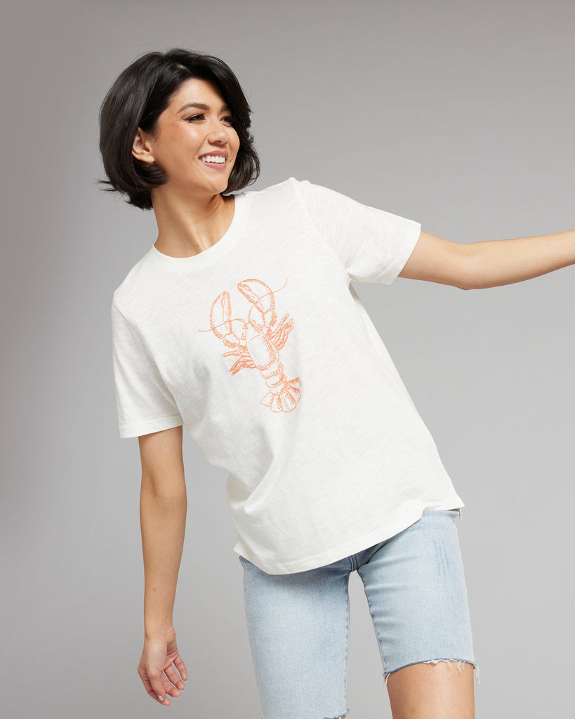 Woman in a white short sleeved graphic tee with a lobster on the front