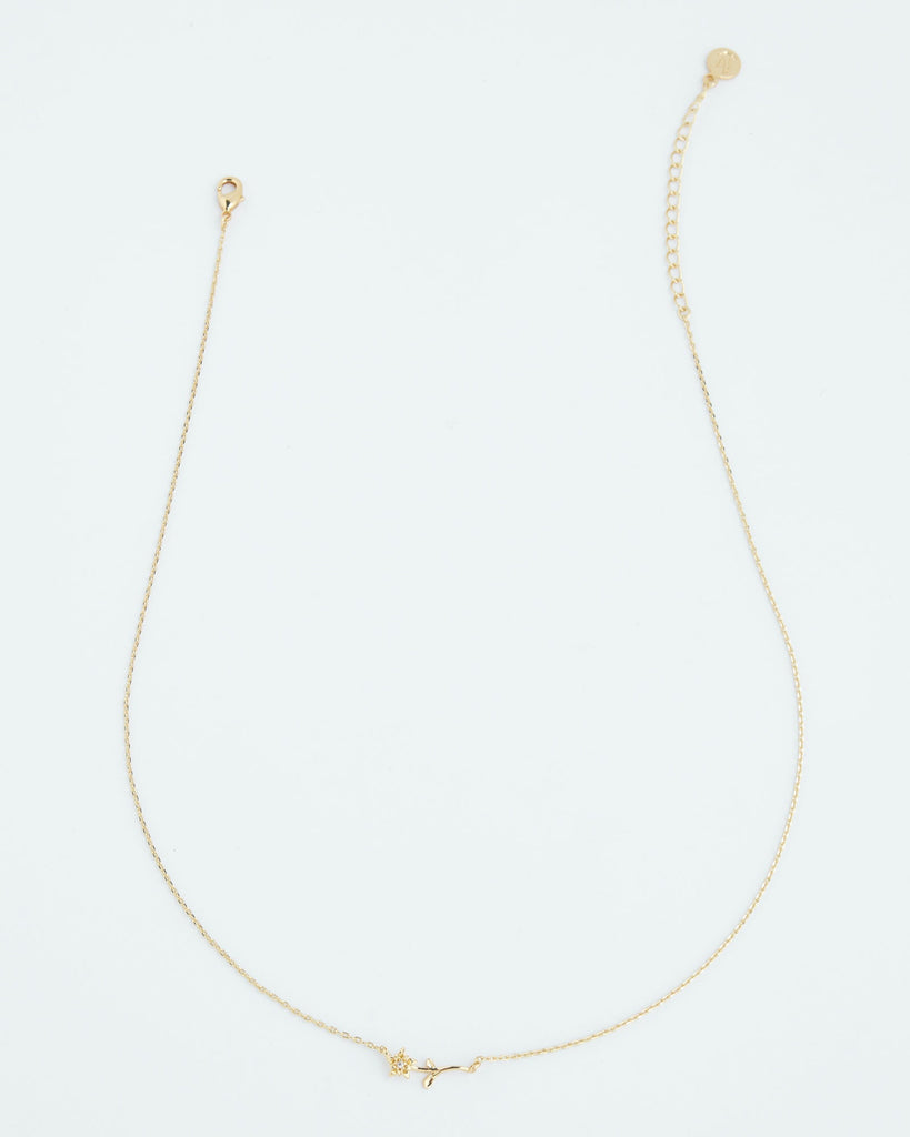 A gold necklace with a dainty flower.