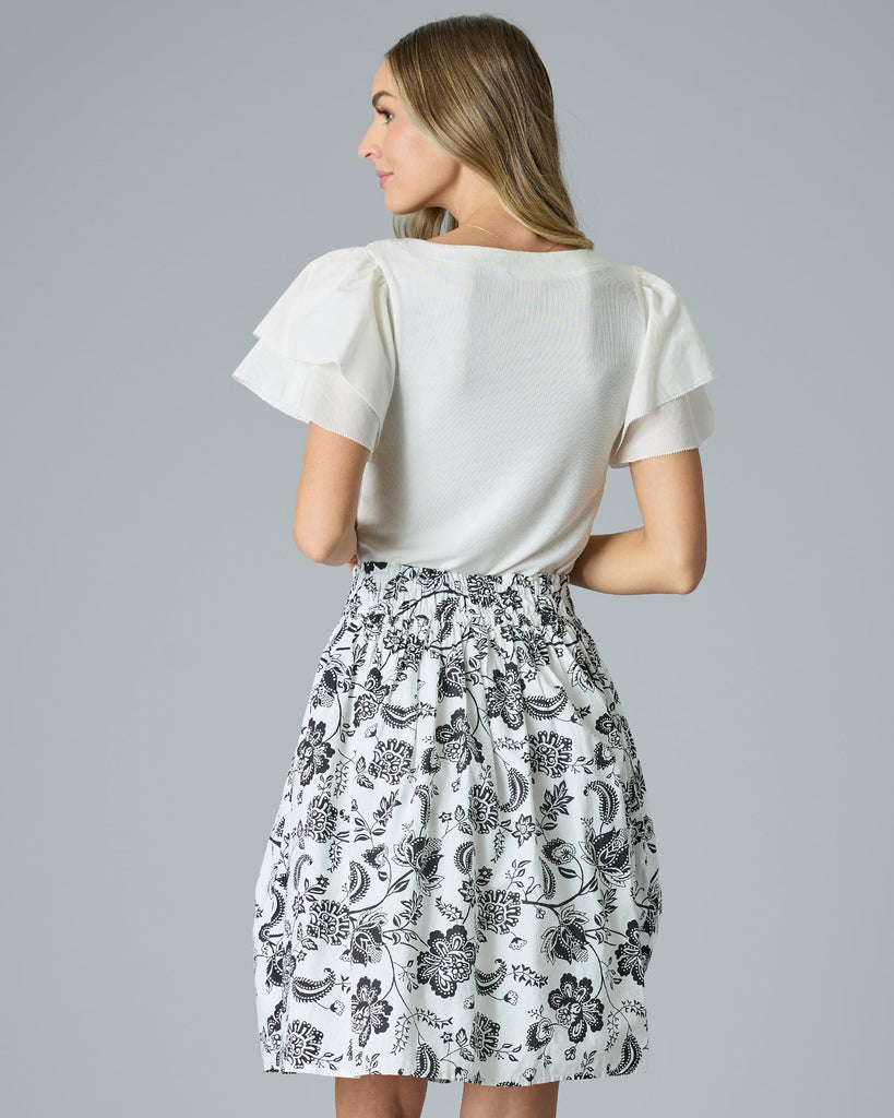 Model wearing a black and white paisley print knee-length flared skirt.