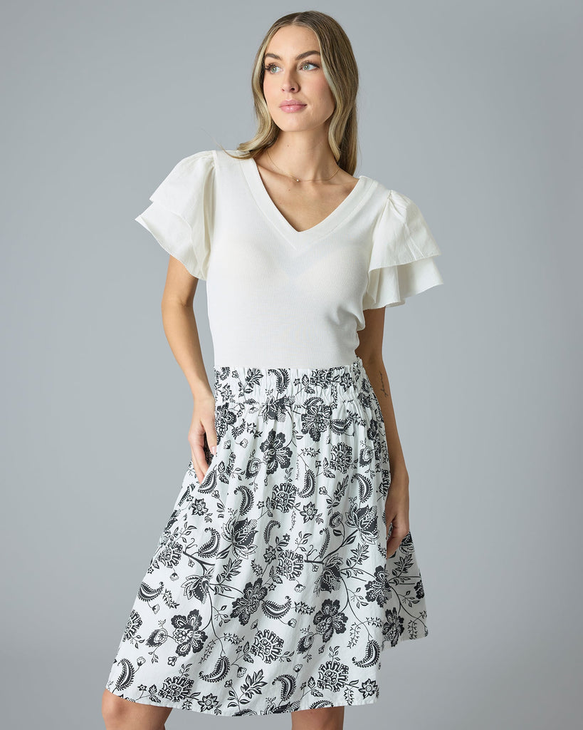 Model wearing a black and white paisley print knee-length flared skirt.