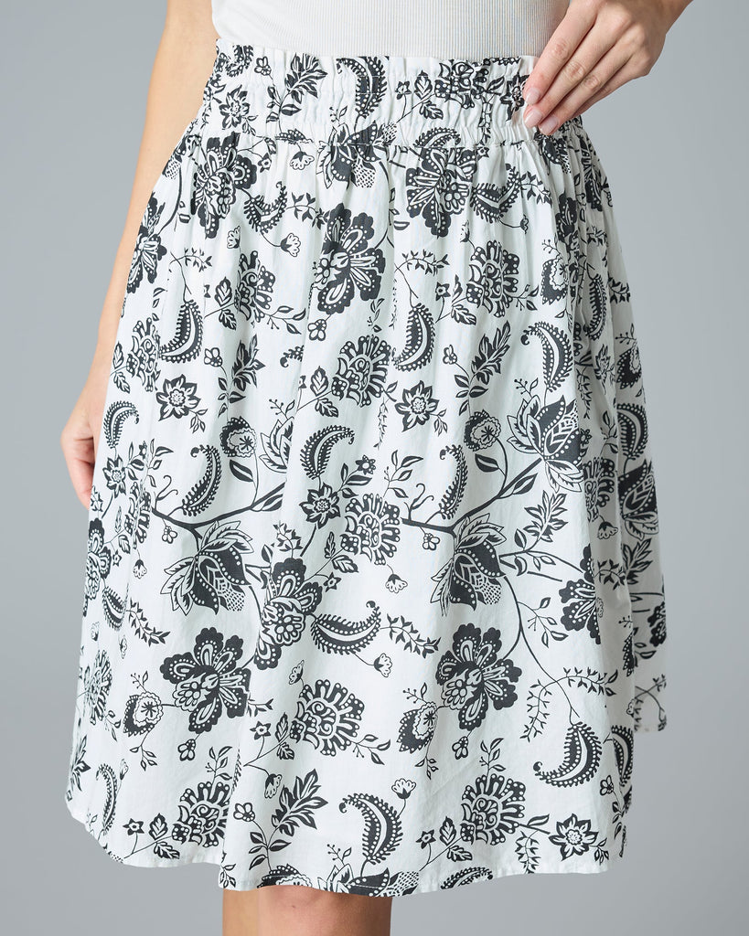 Model wearing a black and white paisley print knee-length flared skirt.