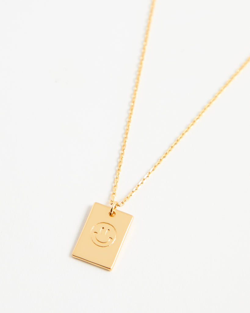 Gold necklace with smiley face pendant