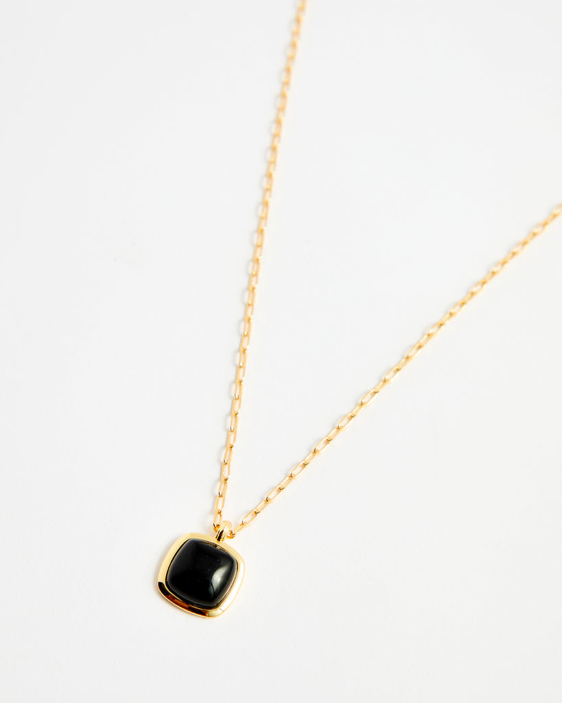 Gold chain necklace with black gem pendant