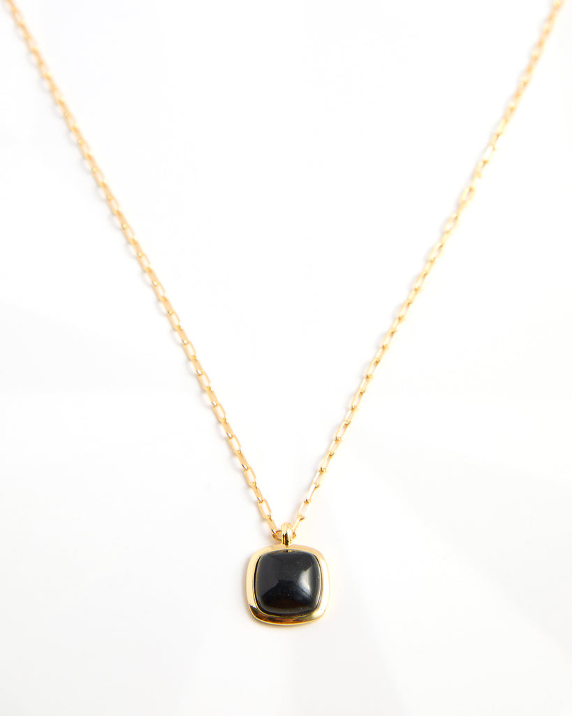 Gold chain necklace with black gem pendant