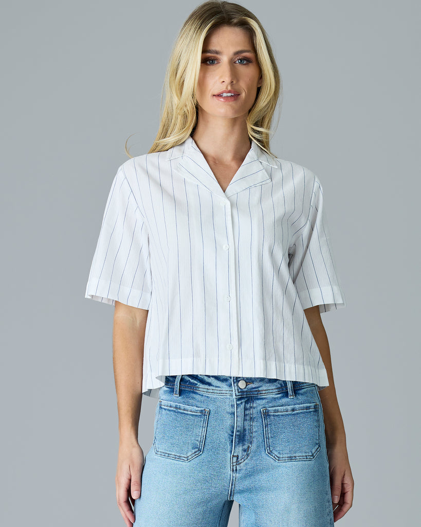 Woman in a white with blue vertical stripes, short sleeve buttondown