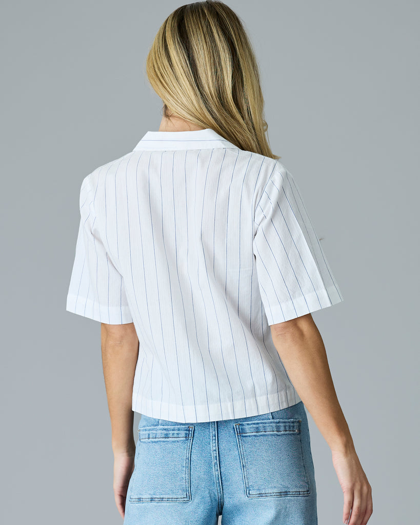 Woman in a white with blue vertical stripes, short sleeve buttondown