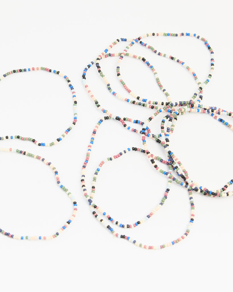 A set of beaded bracelets in various colors of orange, blue, green, black and white.