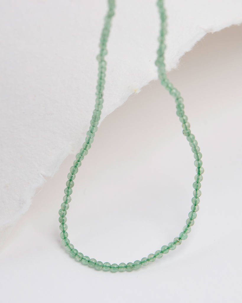 A light green beaded necklace.