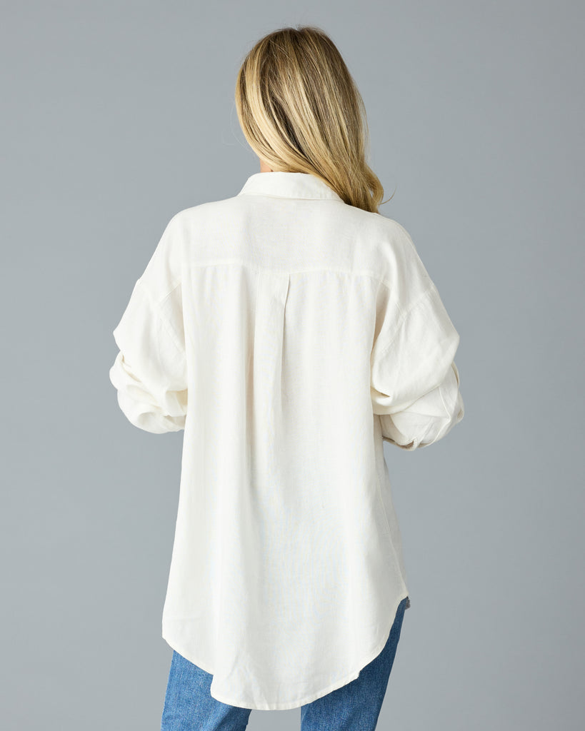 Woman in a white, over-sized, long sleeve buttondown