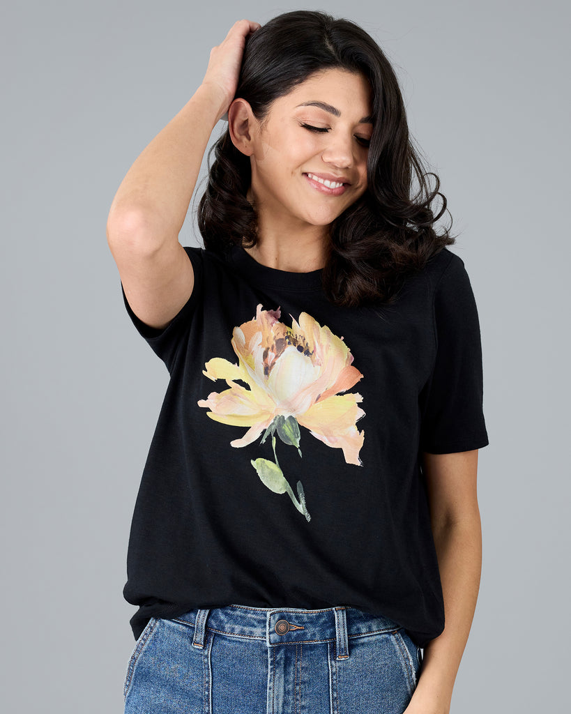 Woman in a black short sleeve tee with floral graphic design