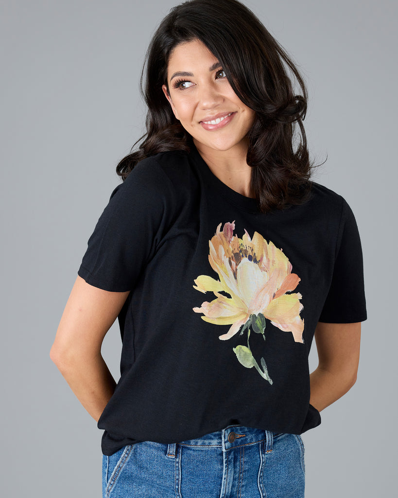 Woman in a black short sleeve tee with floral graphic design