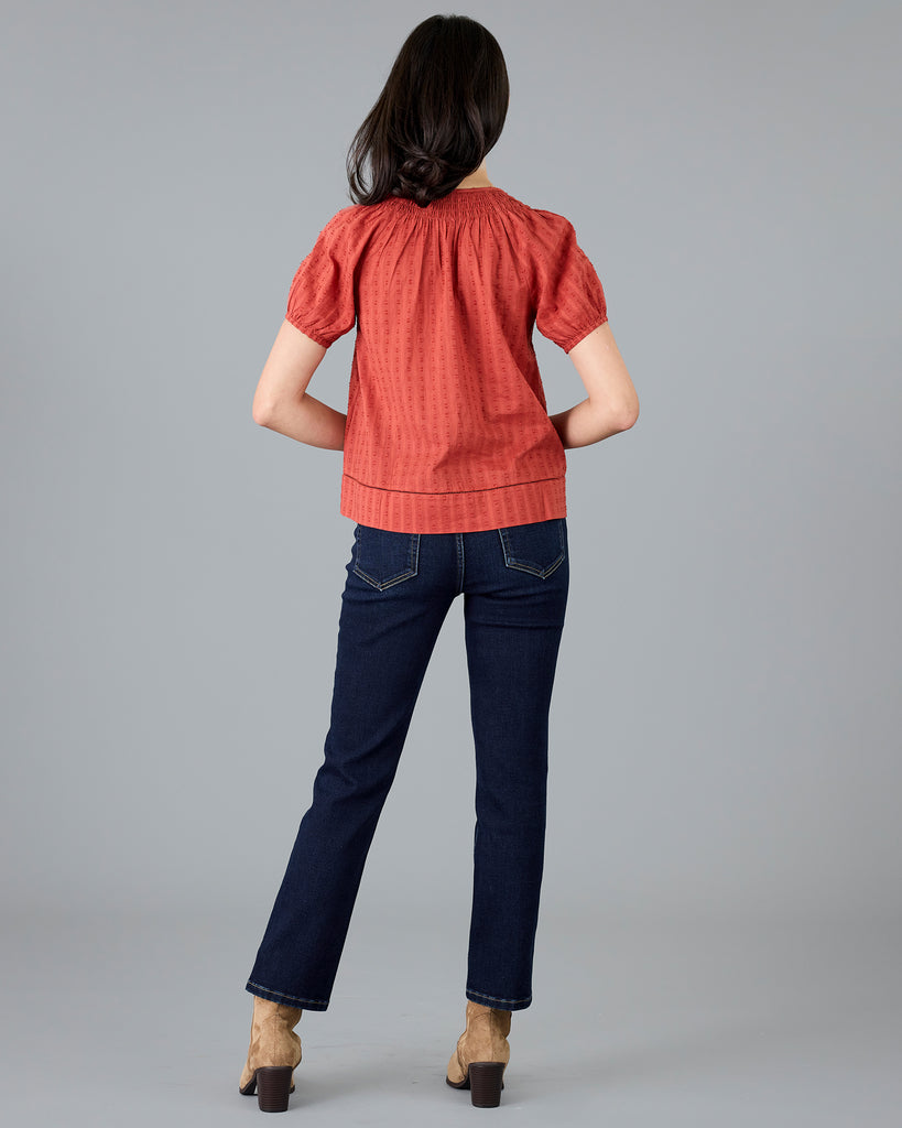 Woman in a short sleeve orange blouse