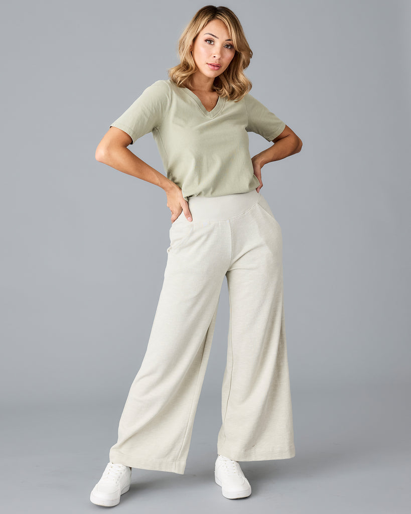 Model wearing a light green, flared, cropped sweatpant.