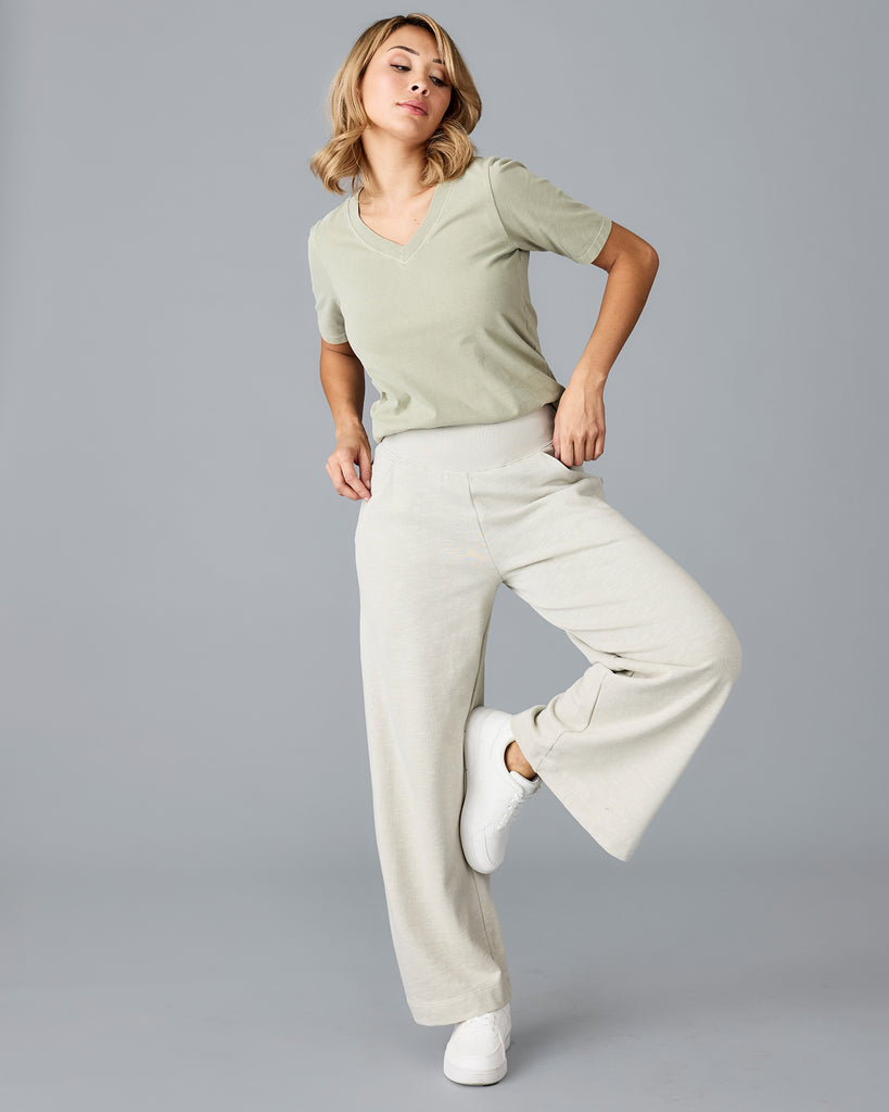 Model wearing a light green, flared, cropped sweatpant.