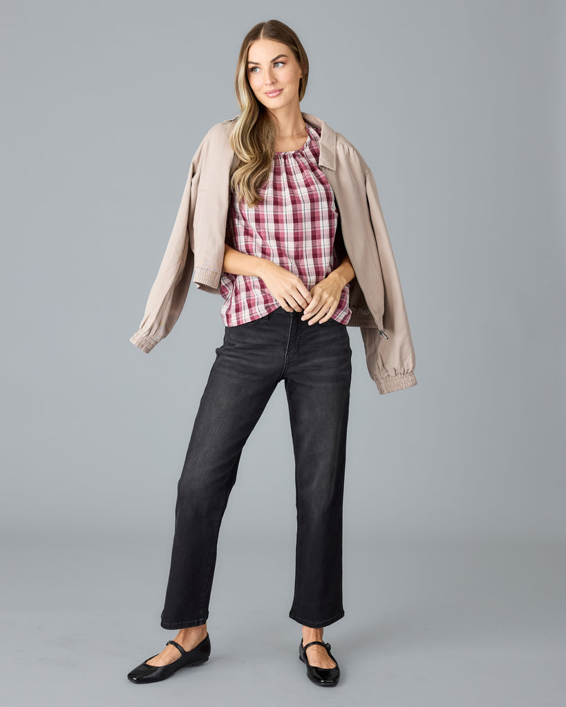 Model wearing a red and white plaid short sleeve, scoop neck blouse.