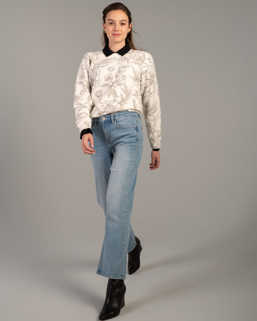 Model wearing light blue flared ankle length jeans.