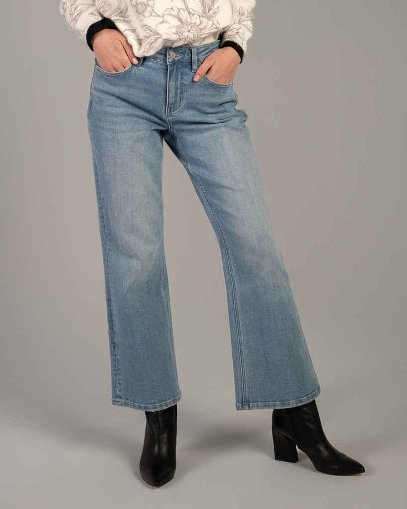 Model wearing light blue flared ankle length jeans.