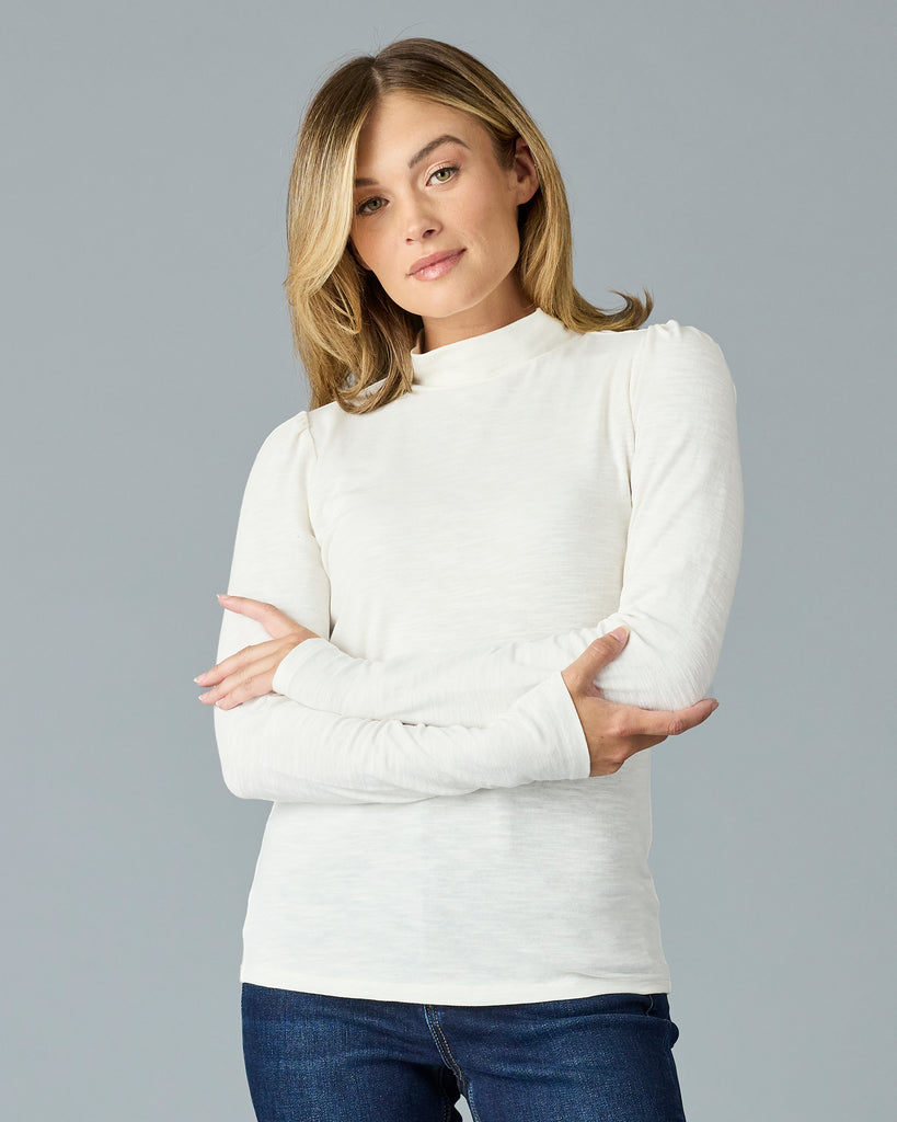 Woman in a white, long sleeve, mock neck basic tee