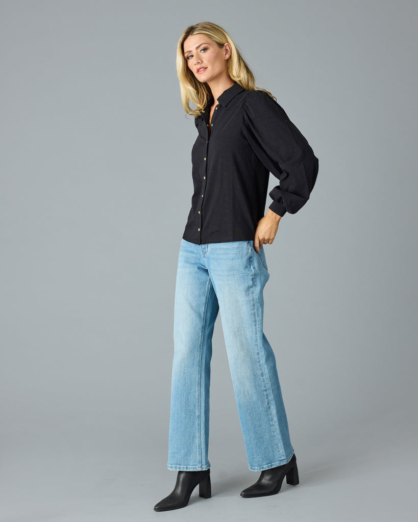 Woman in a black, long sleeve, collared buttondown top