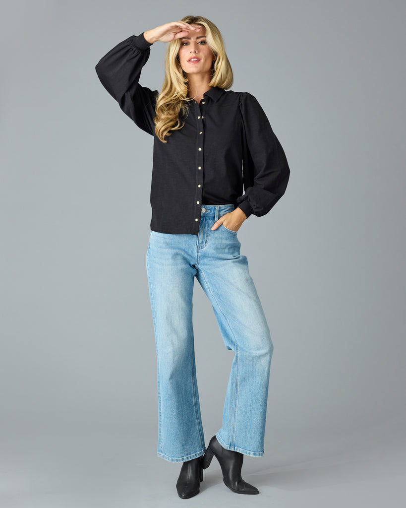 Woman in a black, long sleeve, collared buttondown top