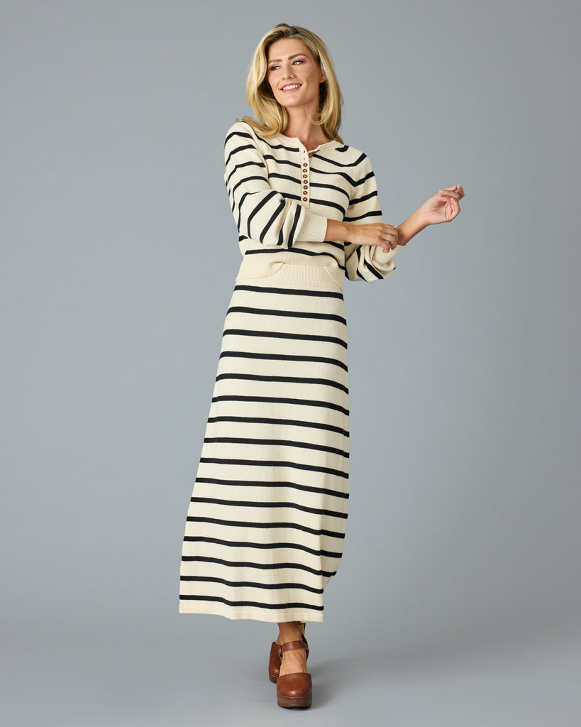 Woman in a black and tan striped maxi sweater skirt with matching sweater