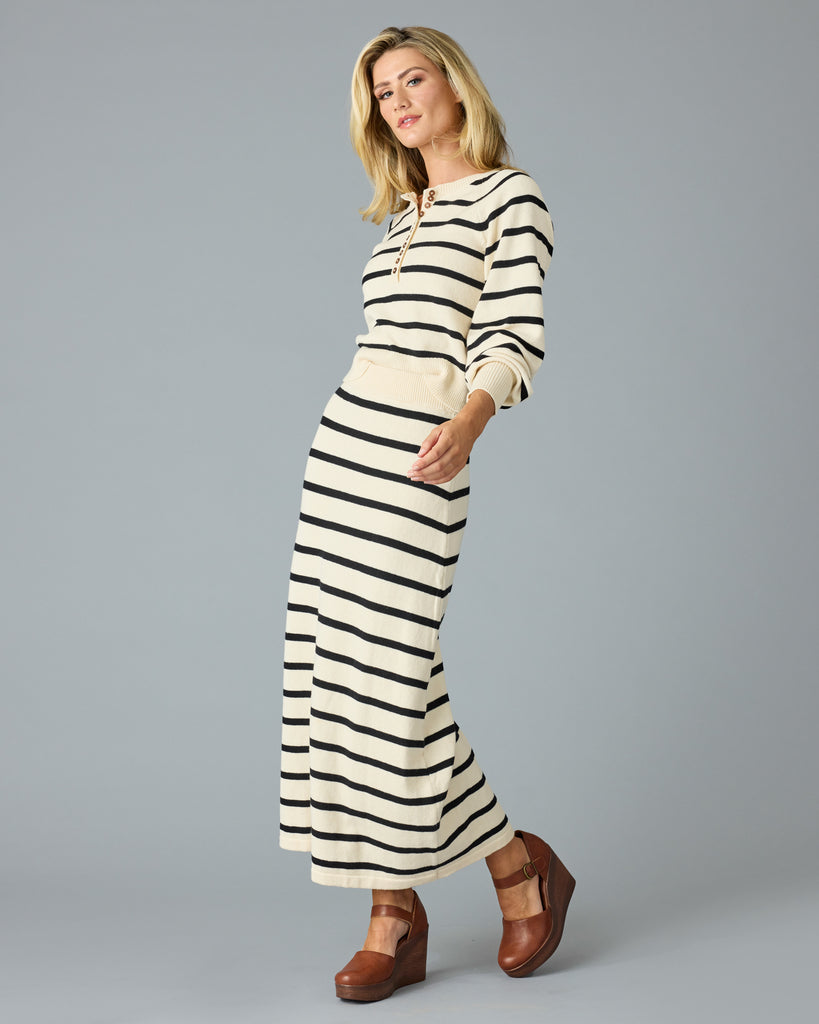 Woman in a black and tan striped maxi sweater skirt with matching sweater