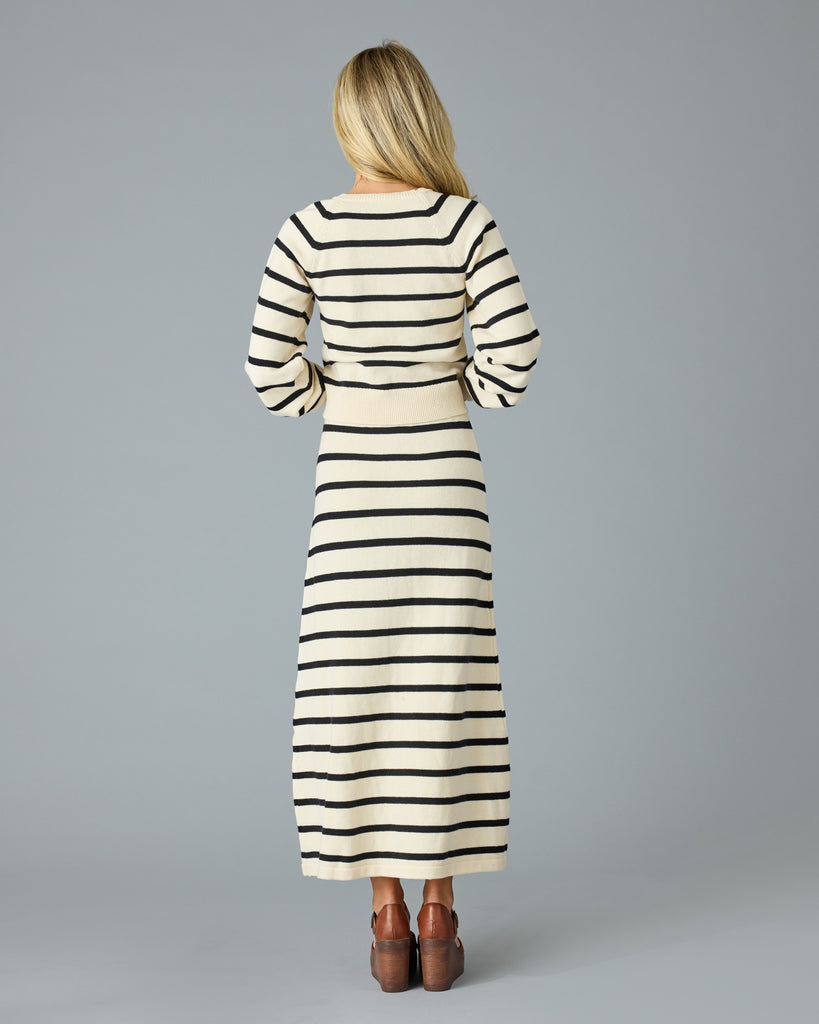 Woman in a black and tan striped maxi sweater skirt with matching sweater