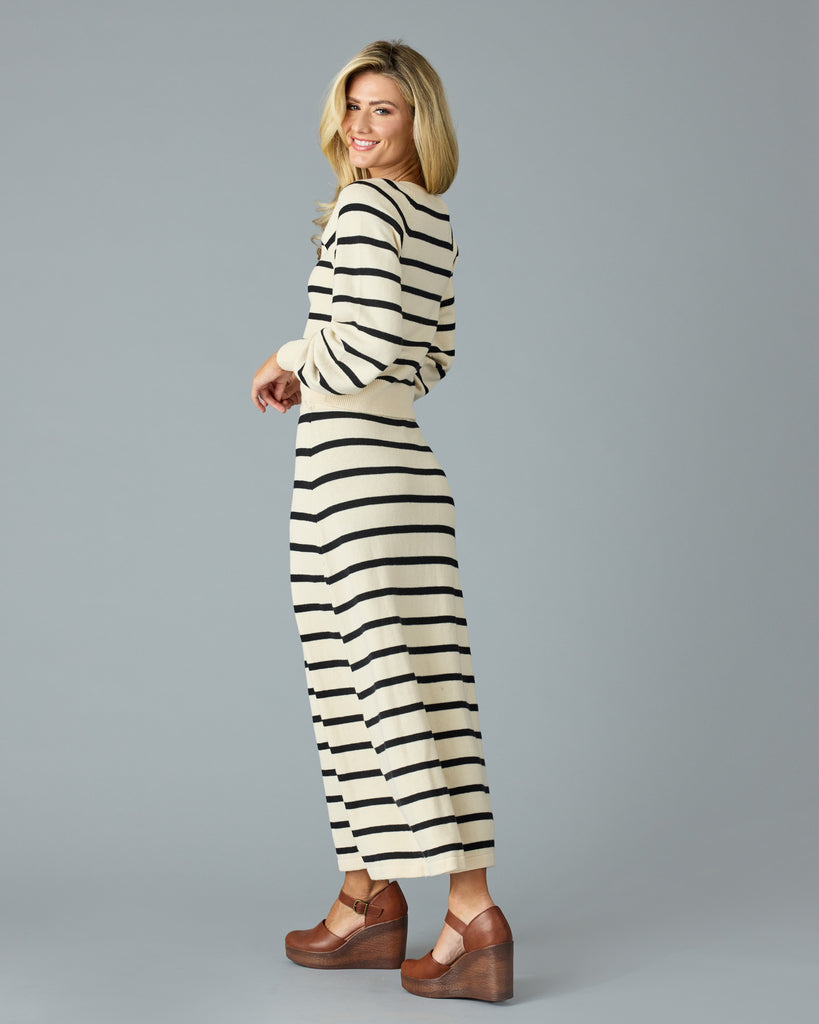 Woman in a black and tan striped maxi sweater skirt with matching sweater