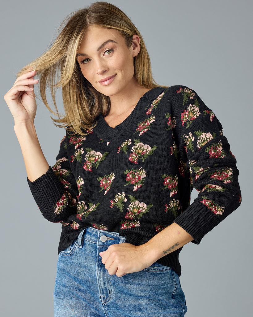 Woman in a black with floral print, long sleeve, v-neck sweater