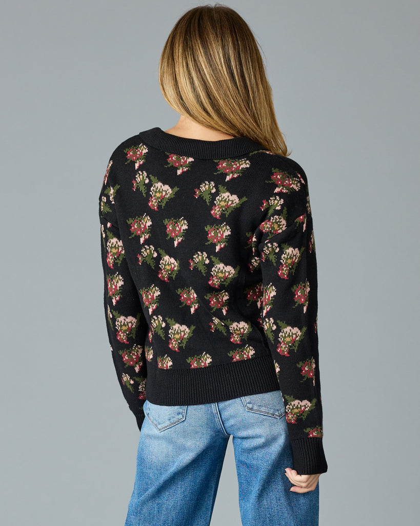 Woman in a black with floral print, long sleeve, v-neck sweater