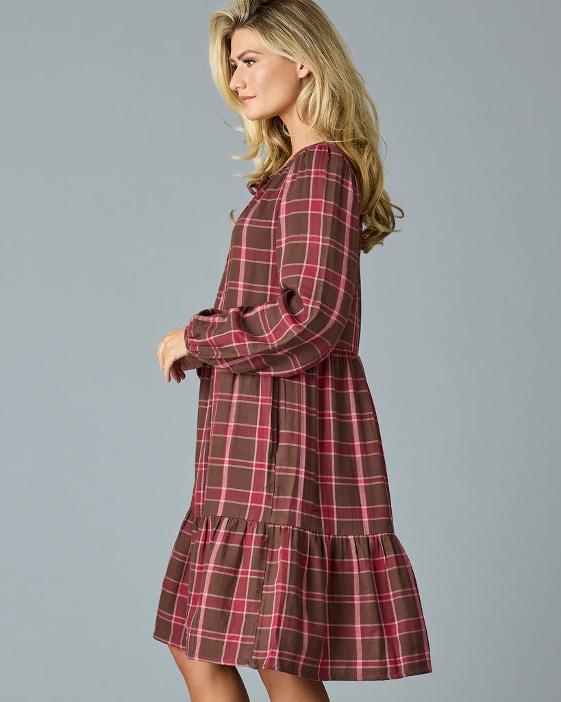 Woman in a maroon plaid, long sleeve, midi dress