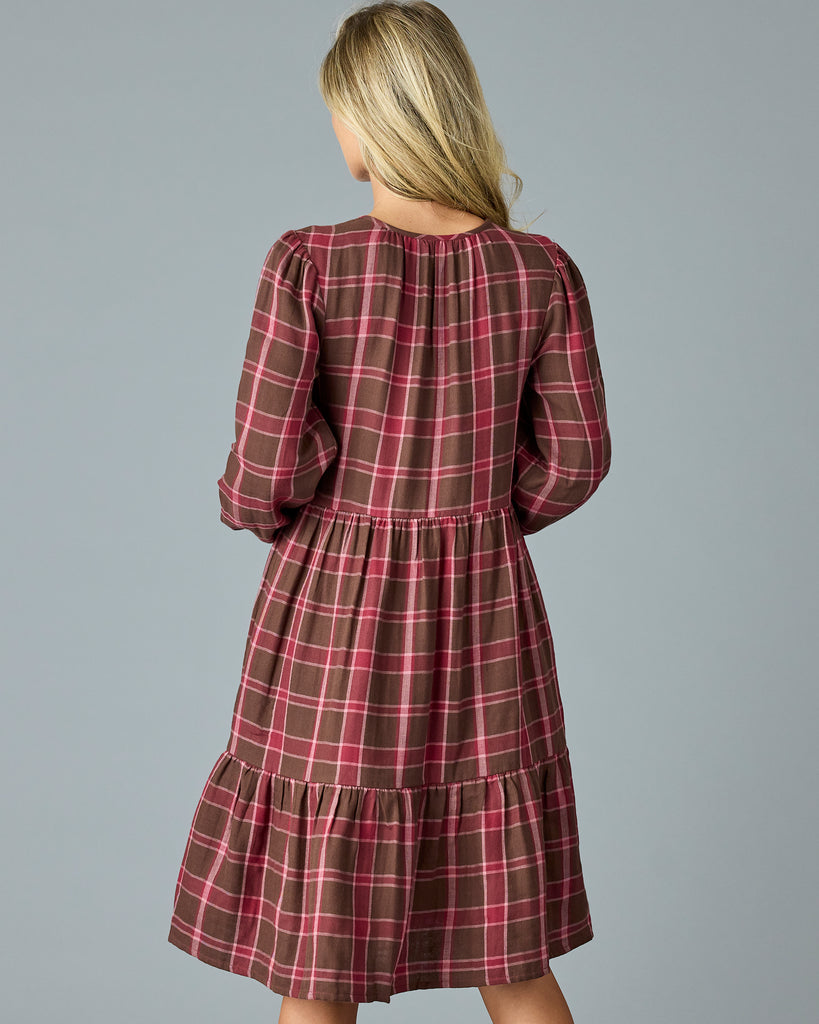 Woman in a maroon plaid, long sleeve, midi dress