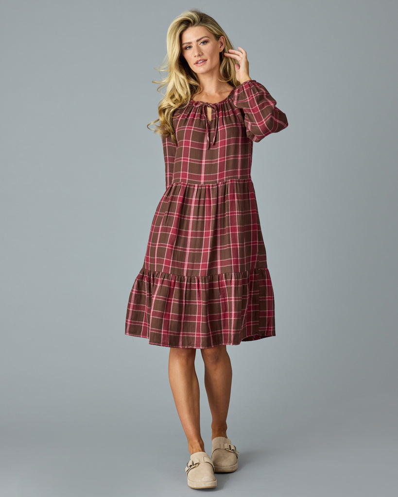 Woman in a maroon plaid, long sleeve, midi dress