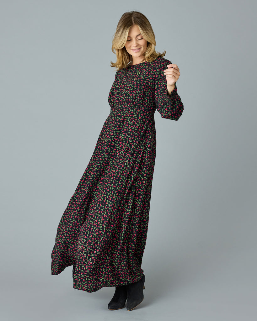 Woman in a black with floral print, long sleeve, v-neck maxi dress