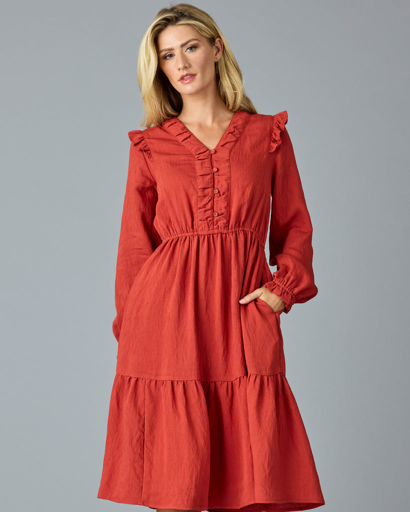 Woman in a red, long sleeve, v-neck, midi dress with ruffles down the front