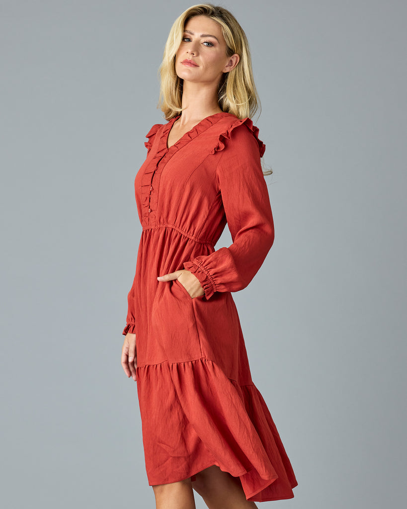 Woman in a red, long sleeve, v-neck, midi dress with ruffles down the front