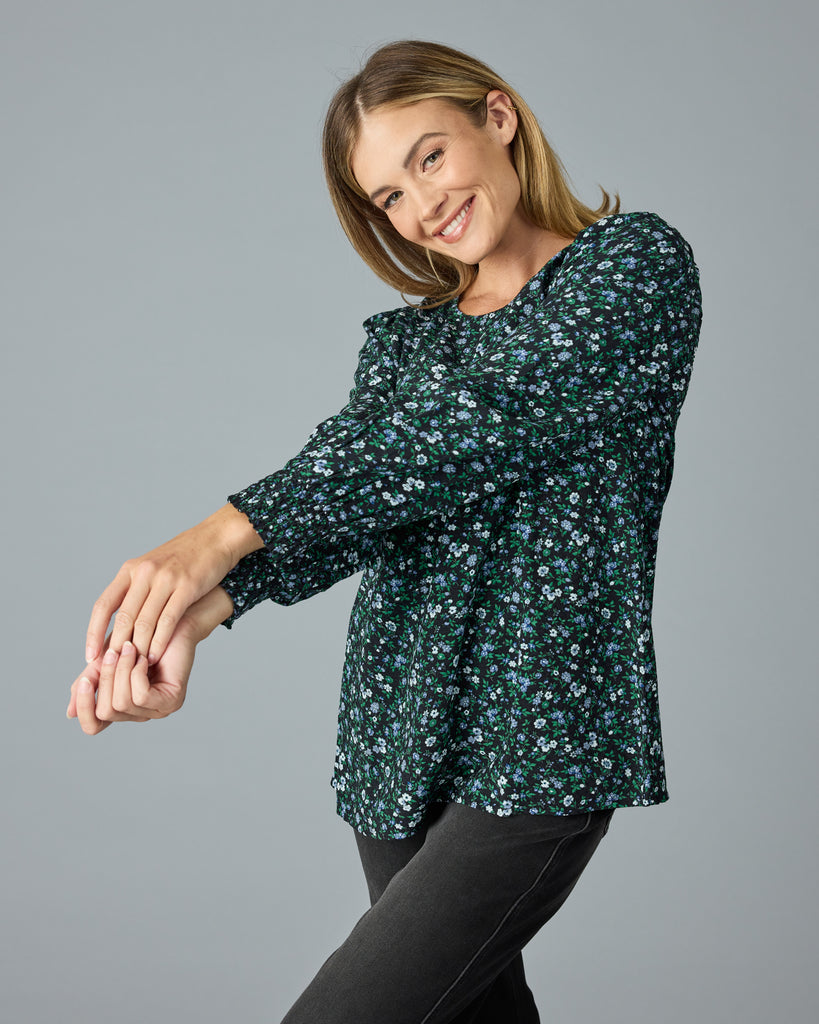 Woman in a green and blue floral print long sleeve blouse