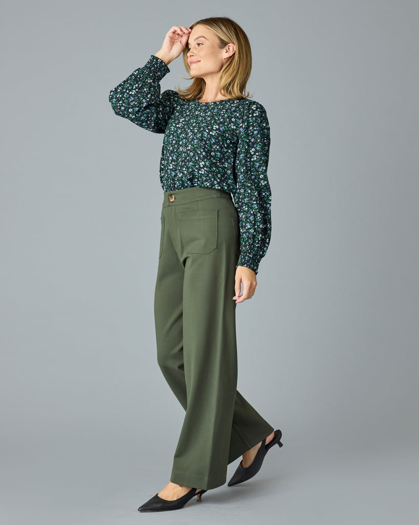 Woman in a green and blue floral print long sleeve blouse