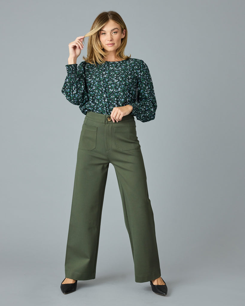 Woman in a green and blue floral print long sleeve blouse